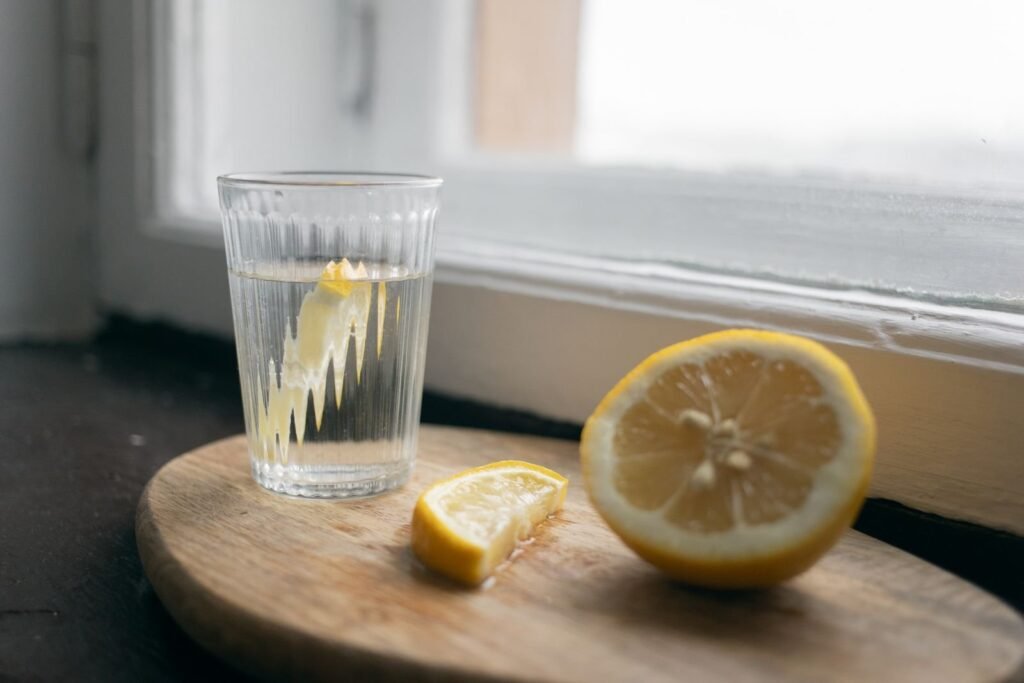 A glass of lemon water with fresh lemon — acidic drinks and tooth enamel